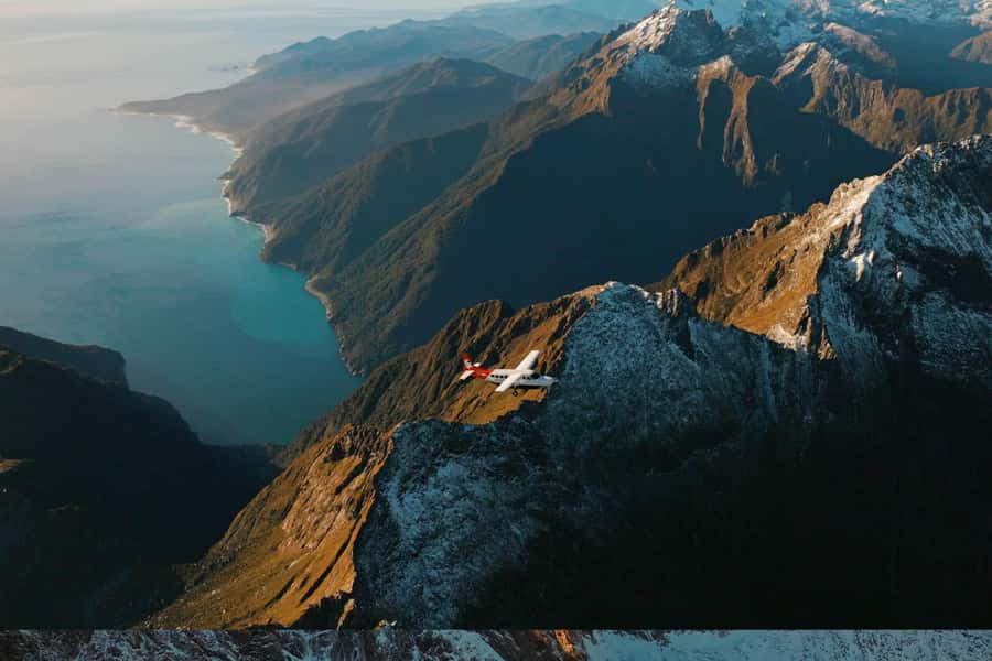 From Queenstown: Milford Sound Coach, Cruise, Scenic Flight - Cruising Milford Sound beneath the cliffs